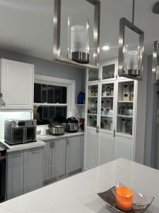 The Door Maker's Deacon Cabinet Doors and matching Mullions and Frames in style Lite 1 in contemporary kitchen. Cabinets color Nordic White and Dove Gray Matte finishes.