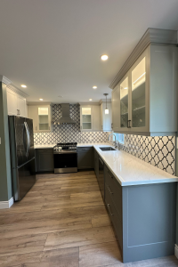 Felm Homes delivers a stunning dual-toned kitchen featuring TDM's Vermont Shaker cabinet door, 2002, 7 edge in White Smoke Super Matte finish on the uppers and Gauntlet Grey on the lowers.