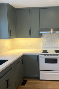 Felm Homes delivers a stunning dual-toned kitchen featuring TDM's Vermont Shaker cabinet door, 2002, 7 edge in White Smoke Super Matte finish on the uppers and Gauntlet Grey on the lowers.